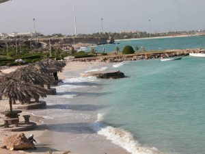 ساحل مرجان در جزیره کیش با آب شفاف و آسمان آبی